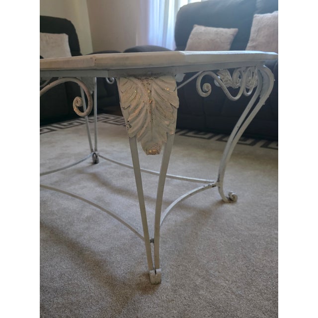 Beautifully hand-forged iron base topped with marble, featuring intricate scrollwork and acanthus leaf accents. The hand-...
