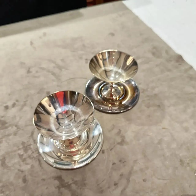 A set of two modernist silver-plated cups and matching plates, designed by the renowned Italian designer Lino Sabattini. A...