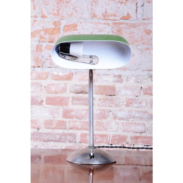 This iconic table lamp, often called the "banker" lamp, is a top example of functionalist Bauhaus design from interwar...