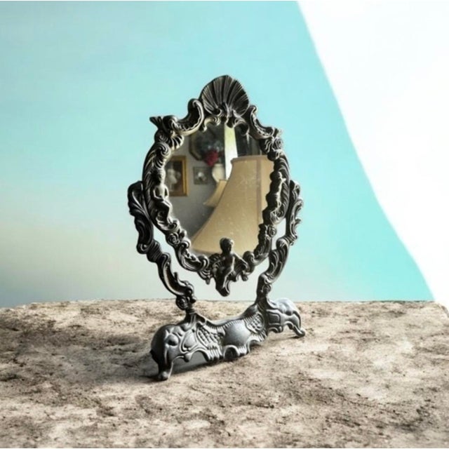 Elegant vintage tabletop mirror with intricate detailing. Perfect for adding a touch of classic charm to any room. Adjustable