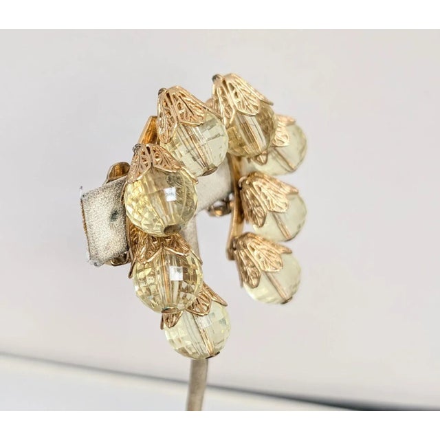 1950s East Indian inspired goldtone filigree tops with yellow faceted disco ball like resin clip back earrings. Marked...