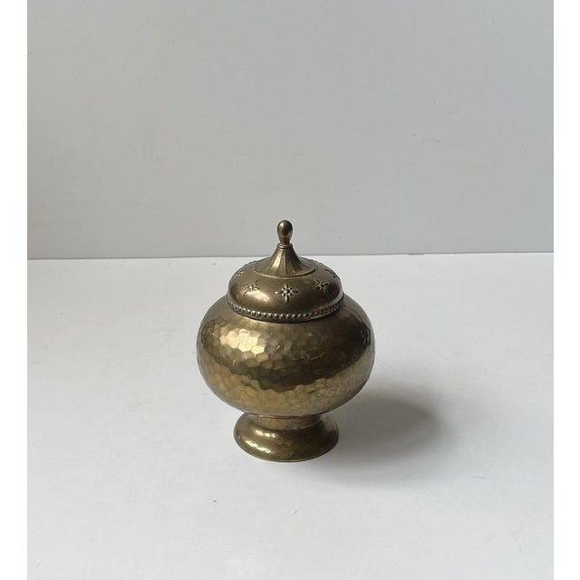 A very well-made trinket or tea jar executed in hand-hammered and hand-embossed thin brass. Its interior is linned with...