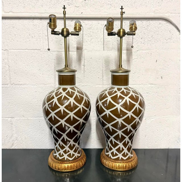 A pair of Bunny Williams Chicken Feather lamps featuring shapely ceramic bodies with a rich brown glaze and an ivory...