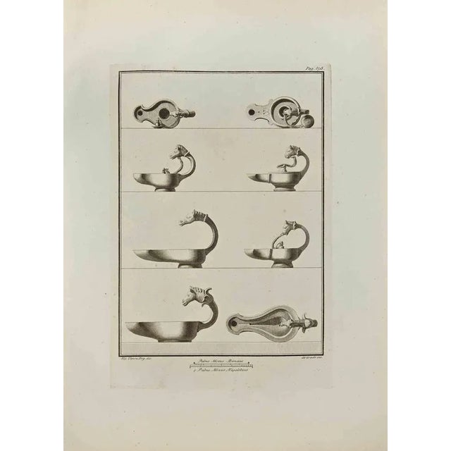Oil Lamp with Heads of Animals from "Antiquities of Herculaneum" is an etching on paper realized by Filippo De Grado in...