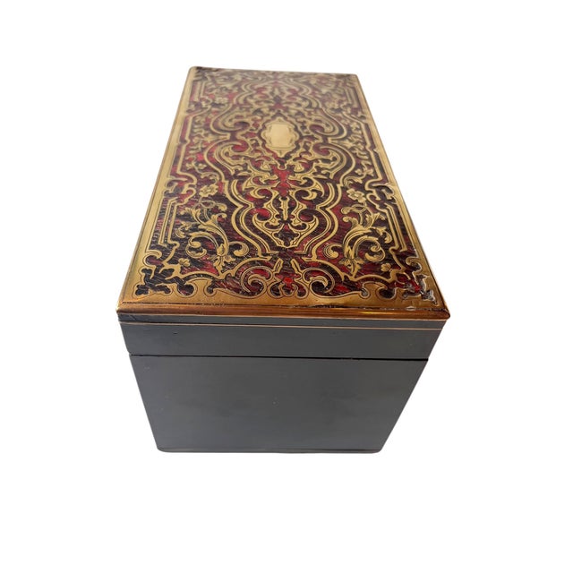 A finely decorated 19th century French tea caddy in the Boulle style, featuring an ebonized case with elaborate brass and...