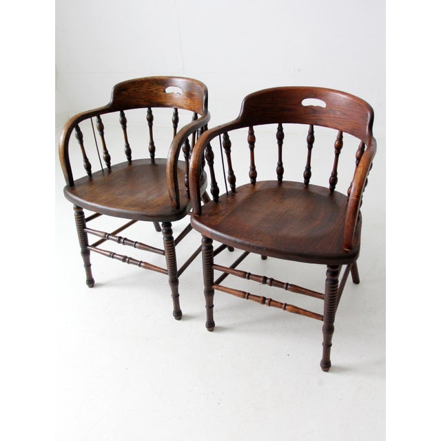 These antique wooden captains chairs offer timeless elegance and comfort. Featuring a curved backrest, spindle detailing,...