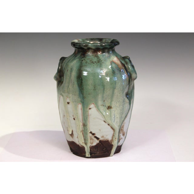 Manipulated Awaji pottery ring handled vase with slashes and dents covered with a thick, multicolored drip glaze, circa...