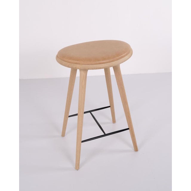 Pair of bar stools by mater made in oak with seats upholstered in natural leather. Mater is a danish furniture...