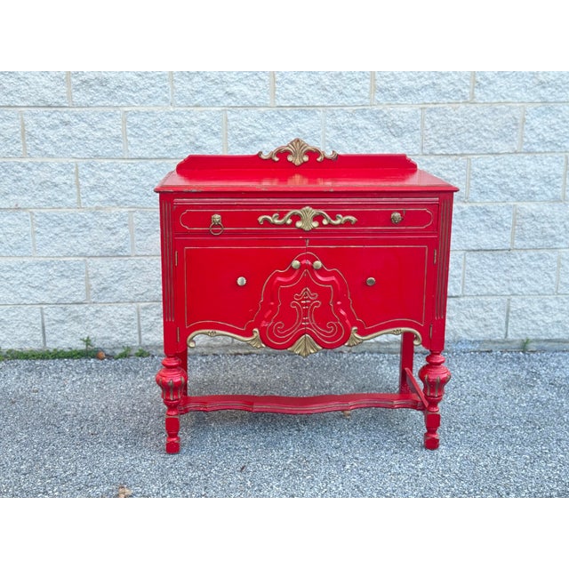 French Provincial style cabinet with carved wood construction. Red painted finish with gilt accent detailing. Single...