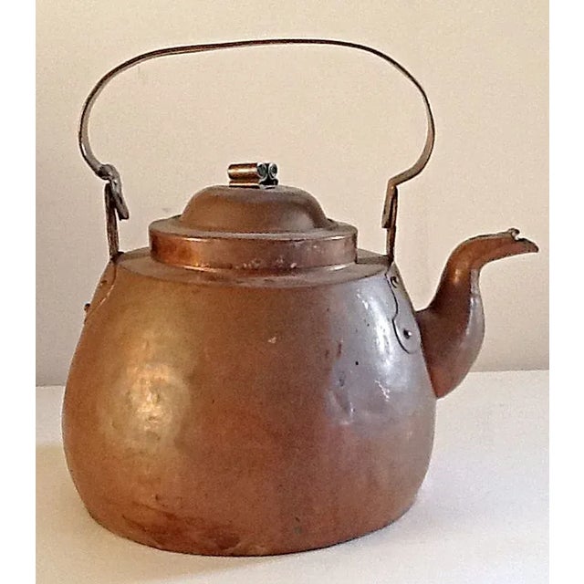 A very old hand forged copper kettle with original patina. There is an old repair to the handle that gives the handle a...