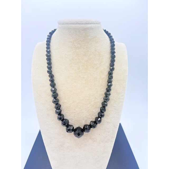 This mid‑century fine jewelry, jet-revival necklace features hand‑faceted natural black onyx beads graduated from 14 mm at...