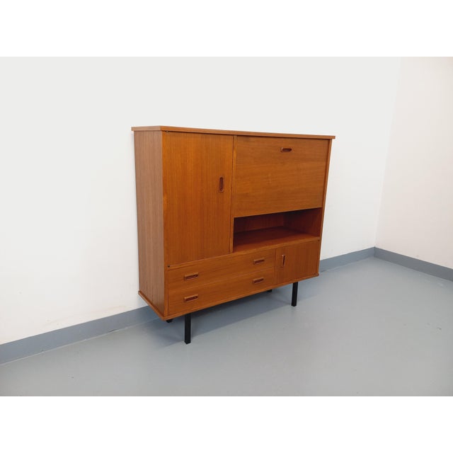 Vintage square bookcase in a Scandinavian modernist style from the 1950s/60s, made of teak with black metal legs and a...