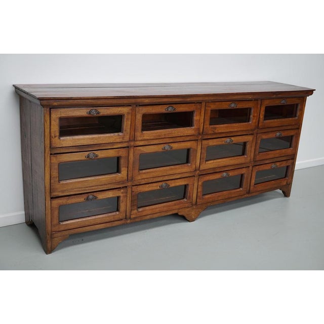 This vintage haberdashery cabinet was produced in the second half of the 20th century in Indonesia. It features 12 large...