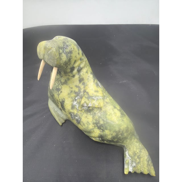 Signed Adla Korgak and made in Canada this Eskimo or Inuit sculpture of a walrus is very well executed I. A variegated...