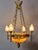 The bronze chandelier with an alabaster bowl and torch lights is an exceptionally decorative light fixture from the period...