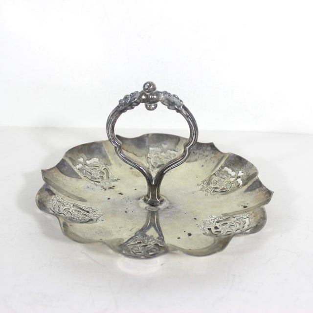Vintage small silver tray with patina, and cutout detail on the ruffled edges and a central handle. This has patina and...