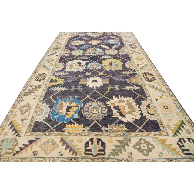 Beautiful modern Oushak hand-knotted wool rug with a charcoal field. This Turkish rug has a beige-designed frame with...