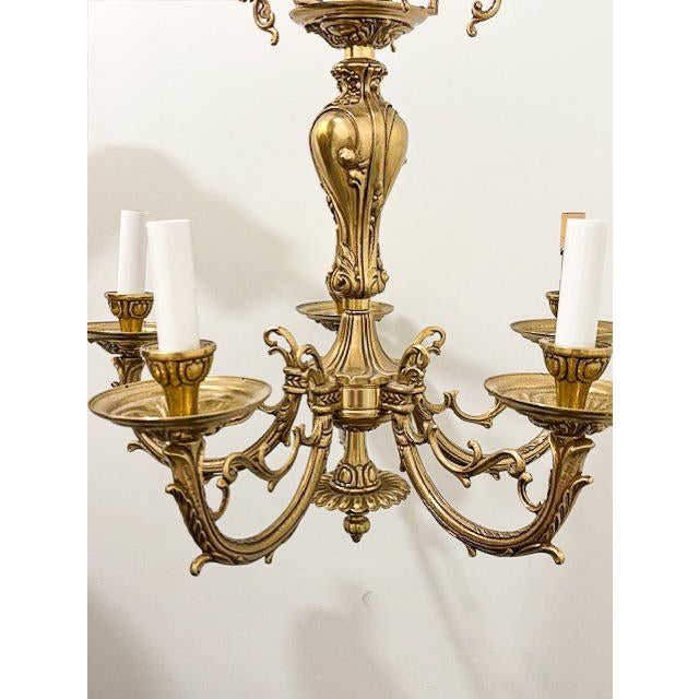 A stunning brass chandelier showcasing intricate engravings in the elegant Art Nouveau style. The design draws clear...