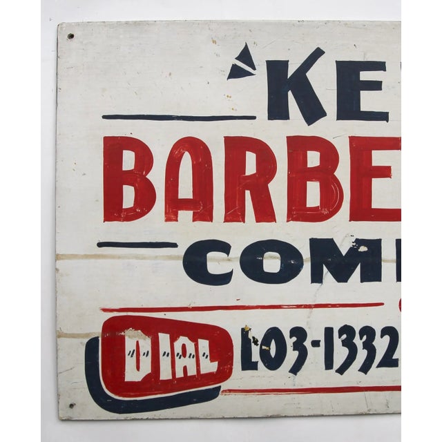 Circa 1950s red, white and blue hand painted sign for Ken's Barber Shop. Sign is one sided and painted on masonite. Sign...