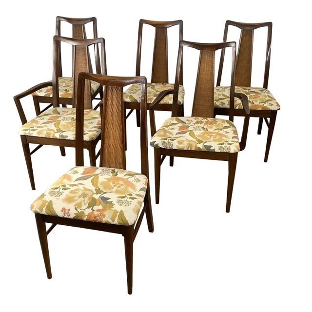 A complete dining set of six mid-century chairs — four side chairs and two armchairs — each built around a tall, tapering...