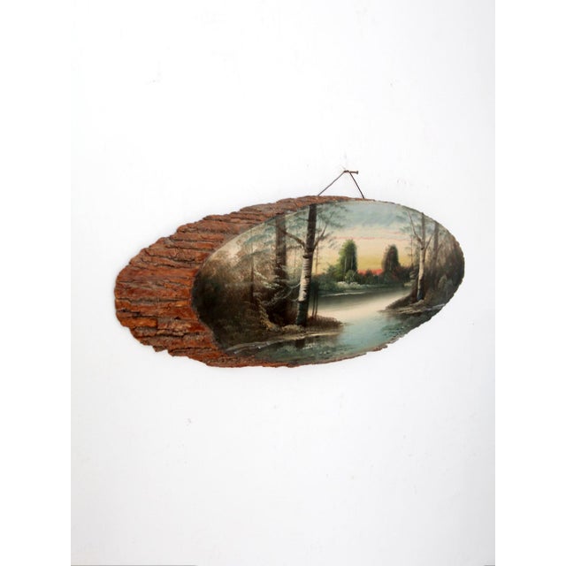 A hand-painted landscape on a natural bark-edge wood slab, depicting a quiet lakeside scene at dusk with soft tonal shifts...