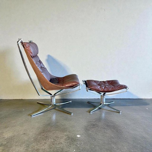 High back brown vintage leather Falcon chair designed by Sigurd Resell with matching ottoman in chrome. In good vintage...
