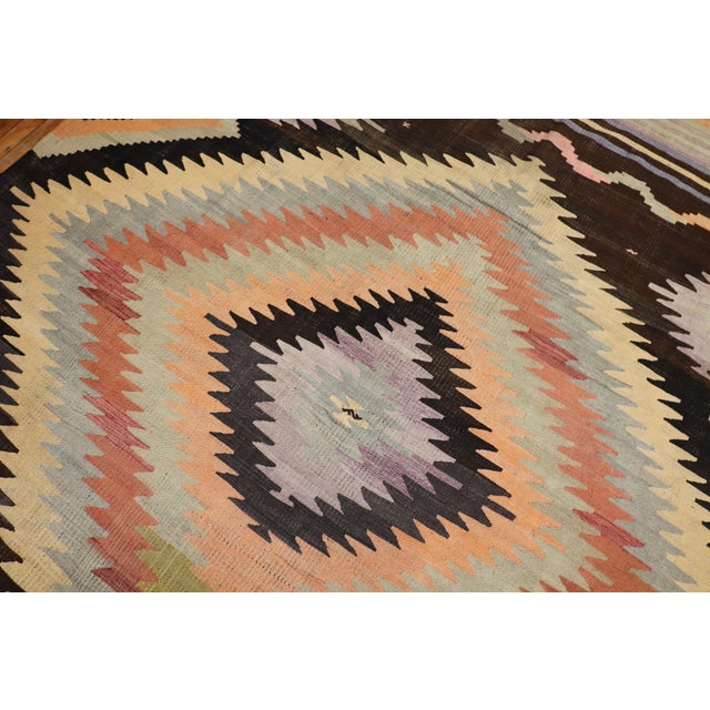 Room size Turkish Kilim from the mid-20th century. The field is brown, accents in canteloupe, peach, light green and...