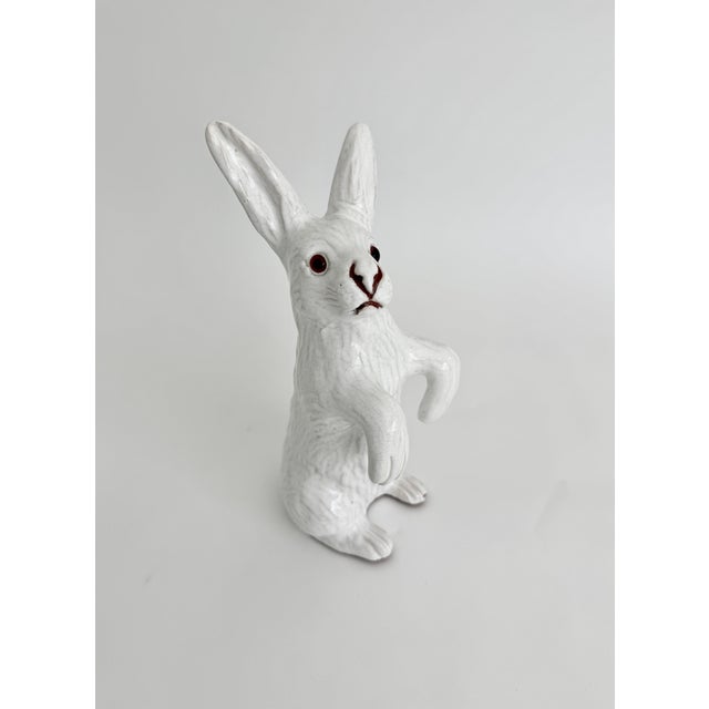 This antique French rabbit features hand-painted details and glass eyes on the "faience" white glazed terracotta...