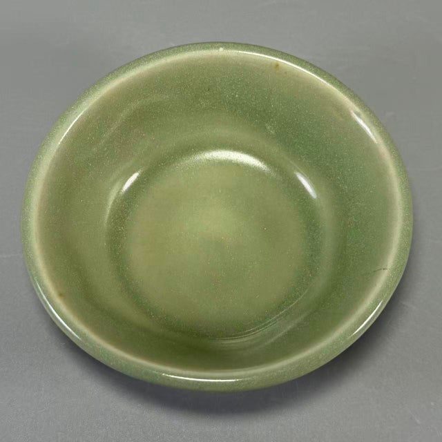 This shallow‑form bowl features classic Longquan‑style celadon glaze with soft mint‑green tone. The unglazed base shows...