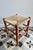 This low vintage stool features a brown-toned wooden frame and a traditional woven straw seat. Its simple silhouette, with...