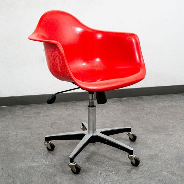 Eames for Herman Miller, rolling red modernica arm shell. Signed beneath.