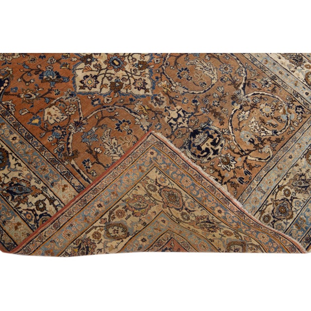 Beautiful antique Tabriz hand-knotted wool rug with the brown field. This Persian piece has a beige frame and blue accents...