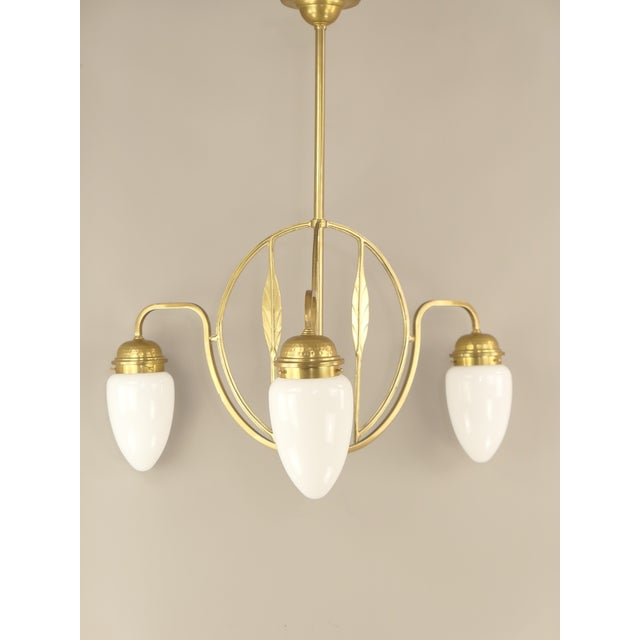Solid brass chandelier with opal glass shade The lamp provides a cozy, non-dazzling light. Polished surface. Solid brass...