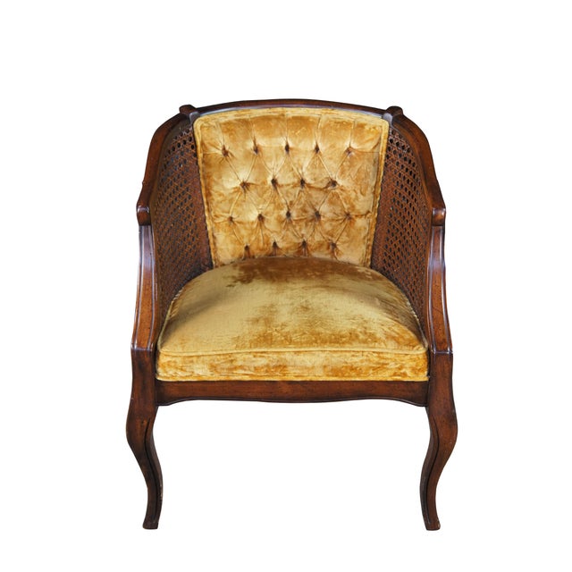 Vintage French Louis XVI style bergere arm chair. Made of walnut featuring a barrel back with tufted velvet upholstery and...
