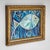Oil on wood painting depicting an abstracted fish rendered in varying shades of blue. The composition reflects a bold,...