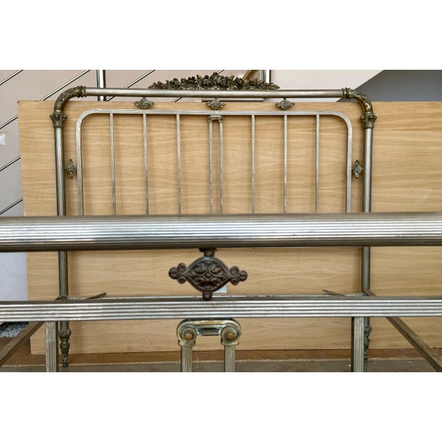Stylish and unusual French antique brass bed. Rectangular in form but with smooth rounded corners, tubular rails and ball...
