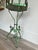Antique green iron plant stand from the art nouveau time period.
