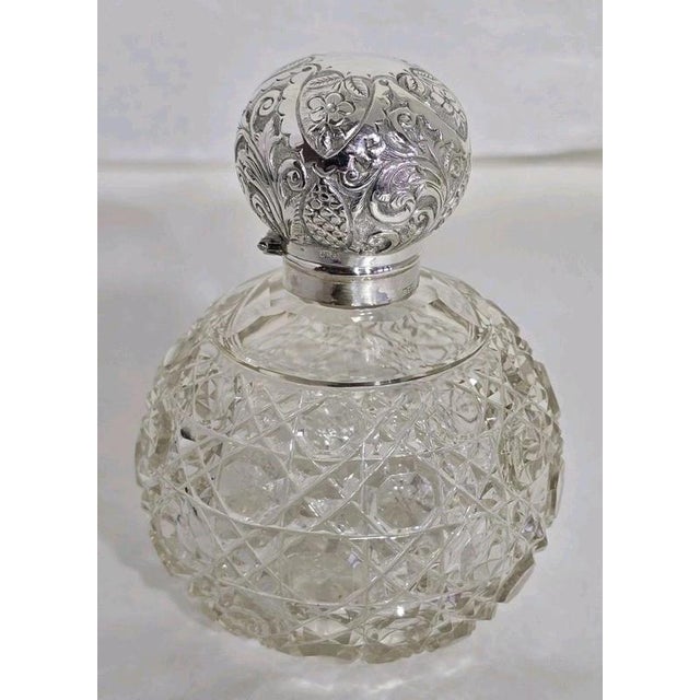 A fine Edwardian cut glass vanity scent bottle dating to 1902, displaying elegant Art Nouveau influences and richly...