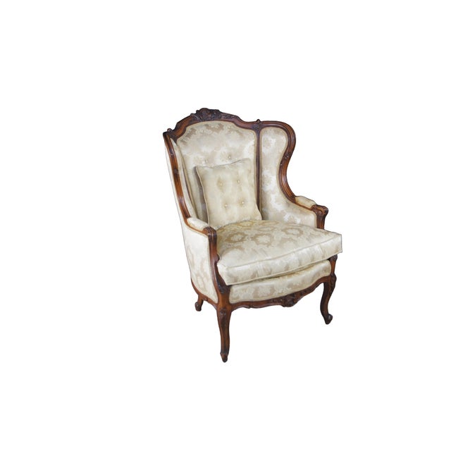 Set of two beautiful antique French bergère wingback armchairs. Made of walnut featuring classic Louis XV styling with...