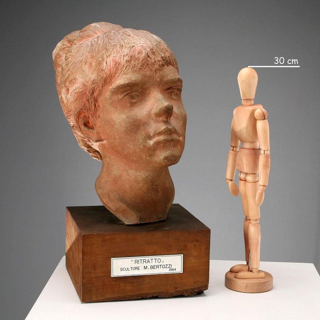 Terracotta sculpture depicting a girl's head. Engraved signature of the artist. This piece is attributed to the mentioned...
