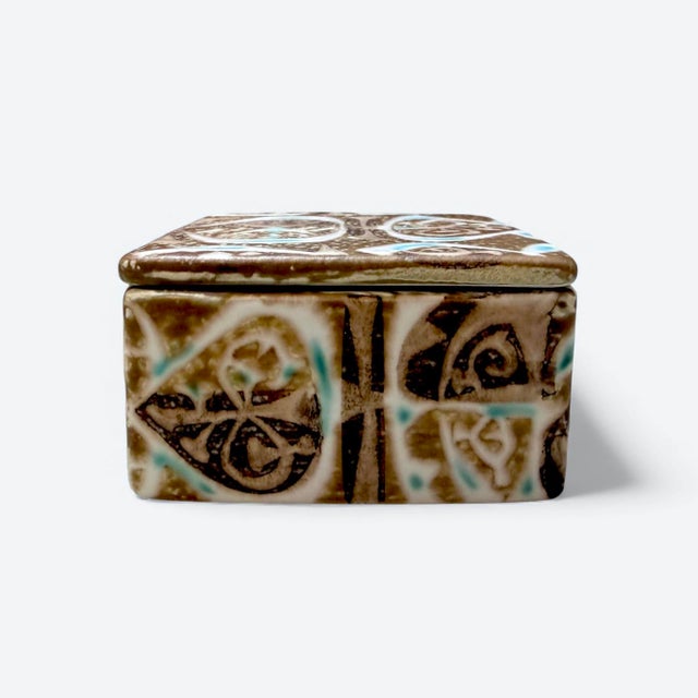 • from the iconic Baca series • Compact lidded square form • Relief-decorated surface • Characteristic earthy glaze tones...
