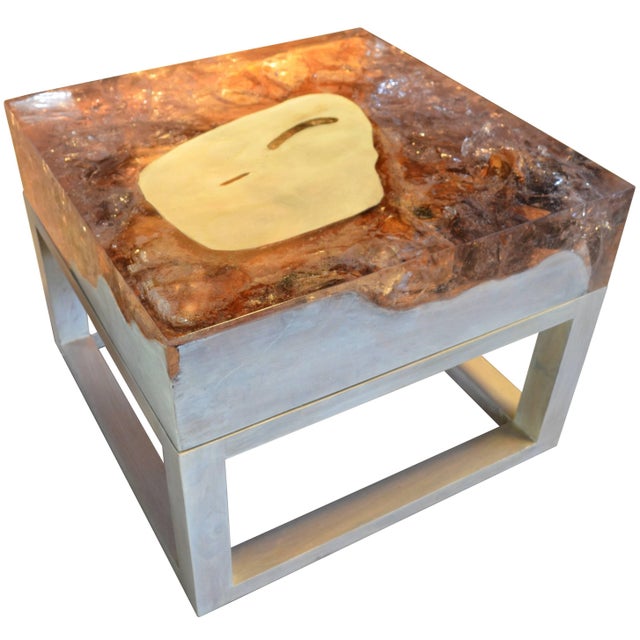 This cracked resin side table or coffee table is made from reclaimed teak infused with clear resin, which resembles a...