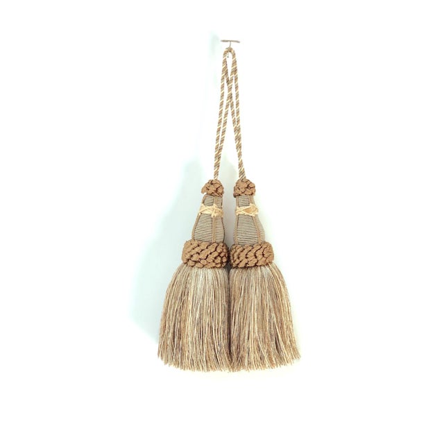Pair of handmade khaki and bronze colored key tassels with looped ruche, twisted cord and full skirt. Skirting contains a...