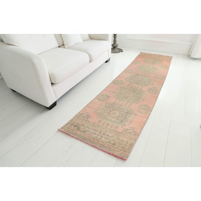 This is a vintage Turkish Oushak rug from the Mid 20th Century. The piece was hand-knotted.