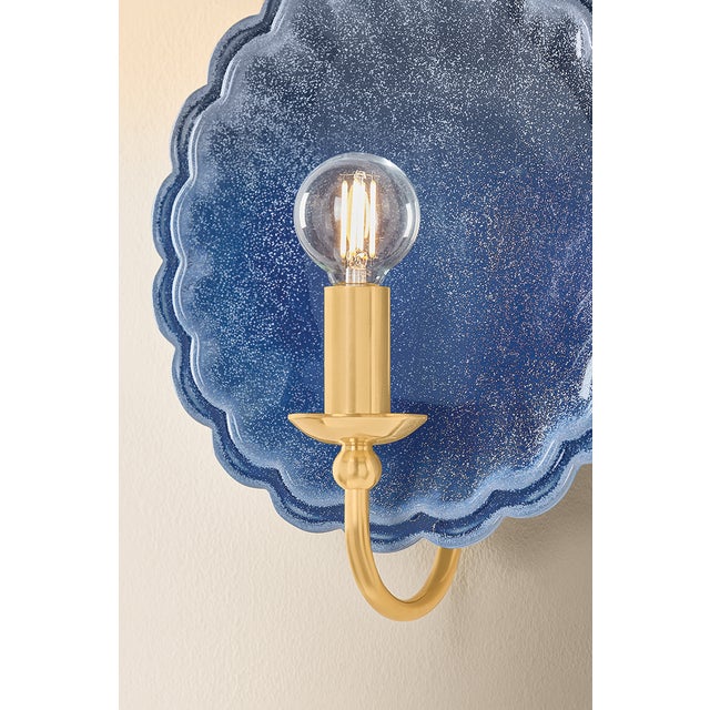 The delicately scalloped Paulette sconce embodies the spirit of new Romanticism, transforming functional lighting into...