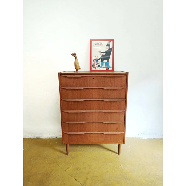 Vintage Danish teak chest of drawers from the 1950s with four drawers and integrated handles, featuring an elegant...