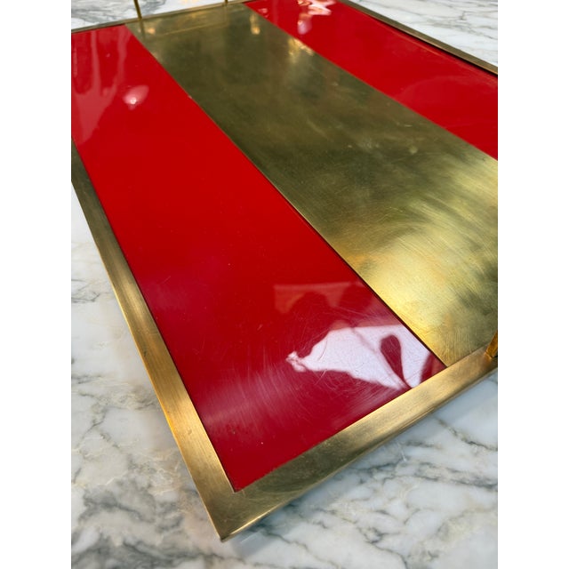 Bold and sophisticated vintage serving tray featuring a vibrant red lacquered surface accented by a brushed brass center...