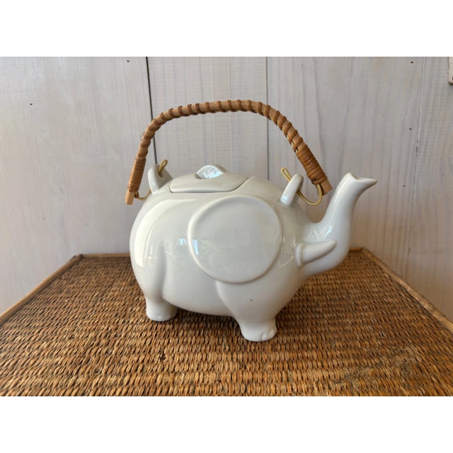 Vintage elephant-shaped teapot! This charming white teapot has lovely stylized detailing and a rattan handle. The perfect...