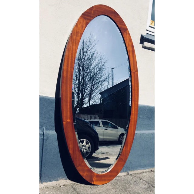 This vintage wall mirror features a solid oak frame with teak veneer and a faceted glass mirror. It was manufactured in...