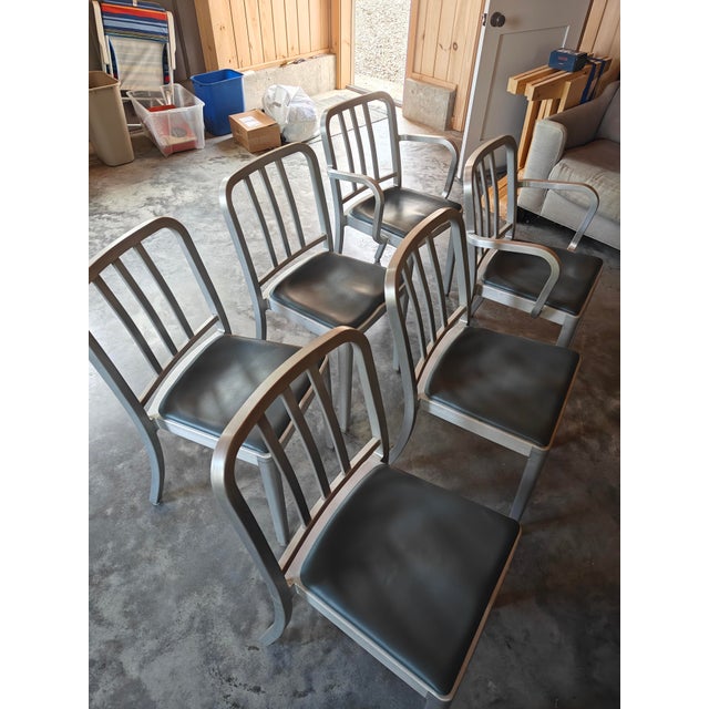 A set of six, authentic Emeco chairs in brushed aluminum, purchased in the 2010s. Chairs all have blue/green seat pads....